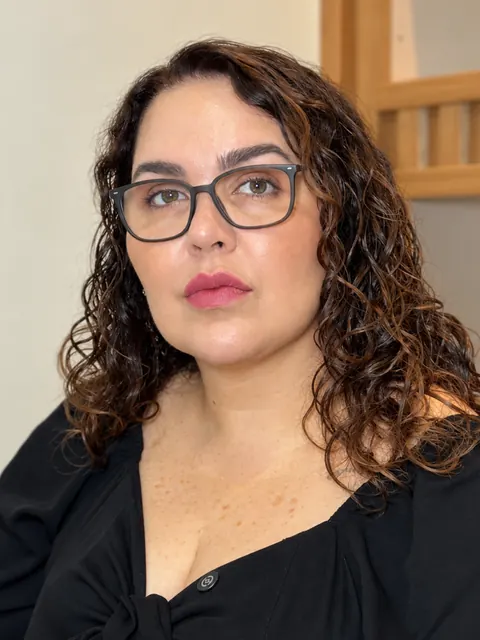 Fany Benette, de óculos, olhando para a câmera